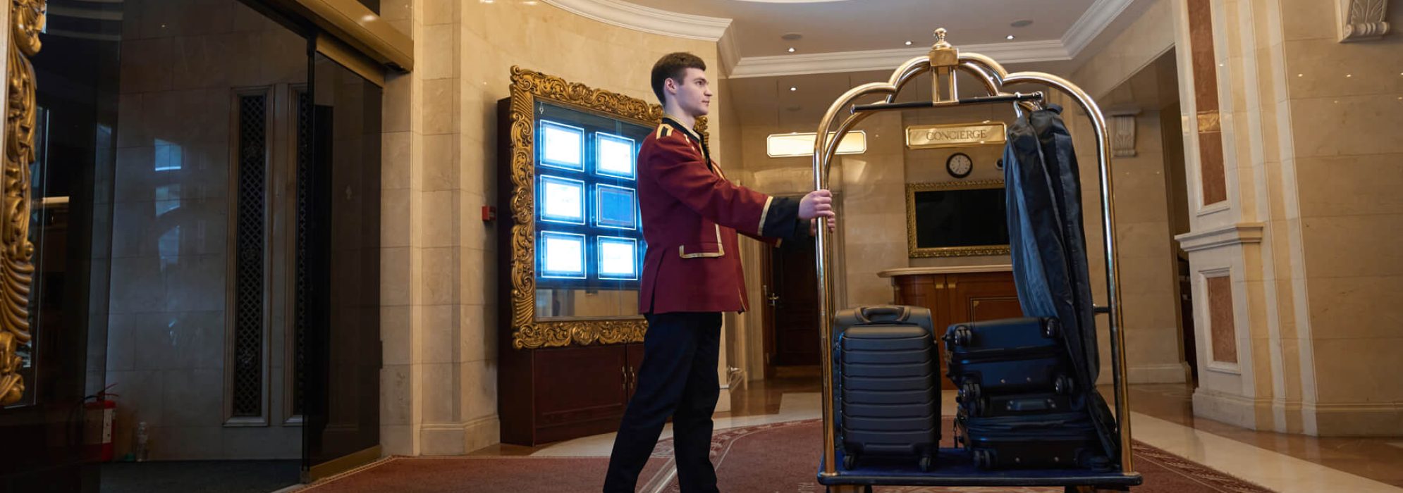 bellhop-in-traditional-uniform-is-carrying-a-cart-2023-11-27-04-53-16-utc.jpg